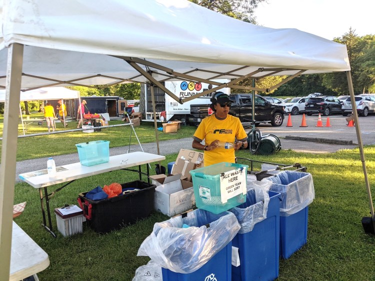 A volunteer managing the Zero Waste recycling tent.